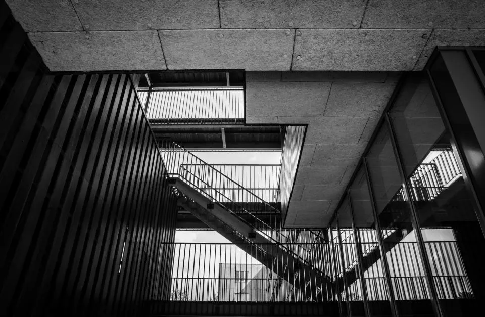 Cage d'escalier ouverte en béton et métal vue en contre-plongée