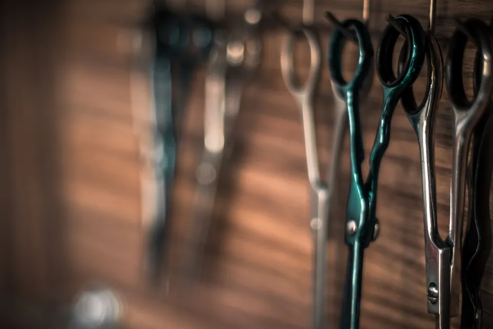 Ciseaux de coiffure suspendus à un mur en bois