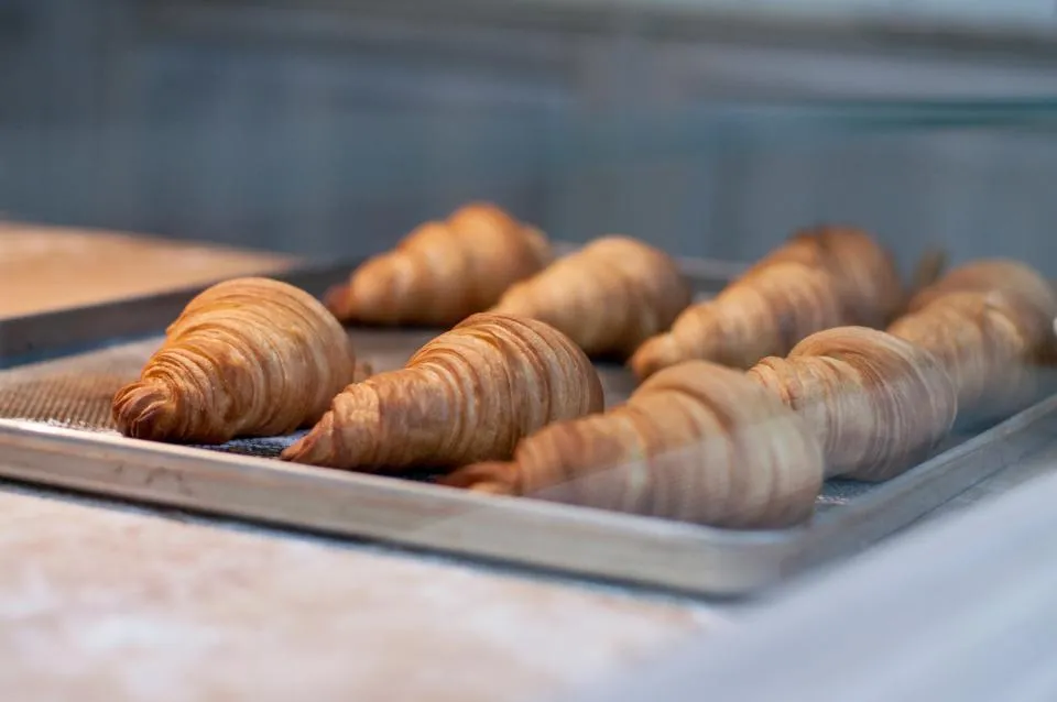 Croissants pur beurre alignés sur une plaque de cuisson