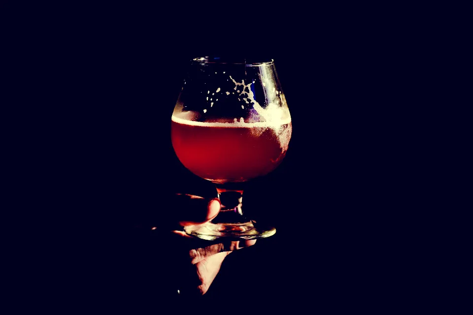 Verre tulipe de bière ambrée sur fond sombre