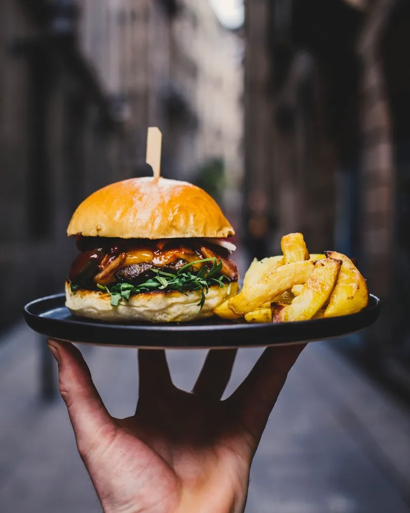Smash burger au cheddar et aux oignons, servi avec des frites