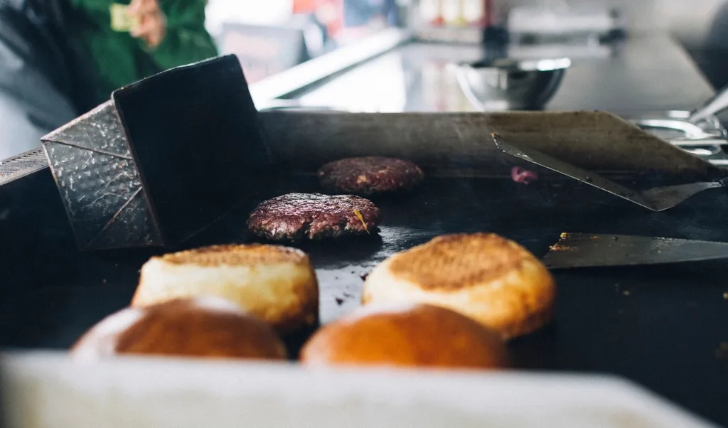 Plancha du camion avec des steaks en train de griller