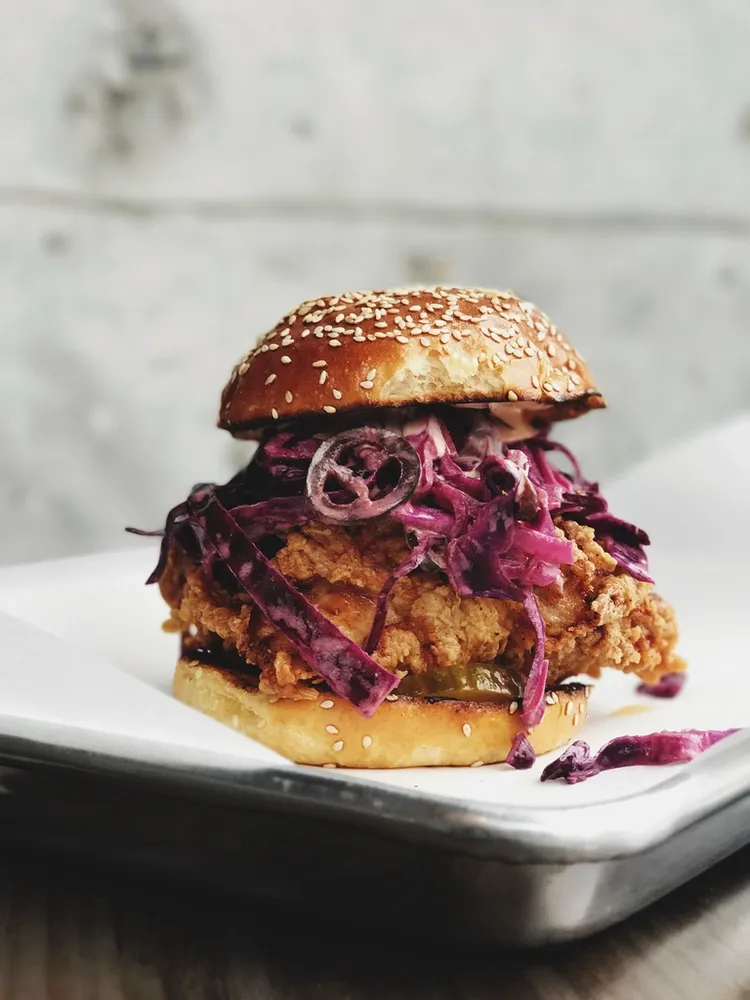 Burger de poulet épicé aux oignons rouges marinés