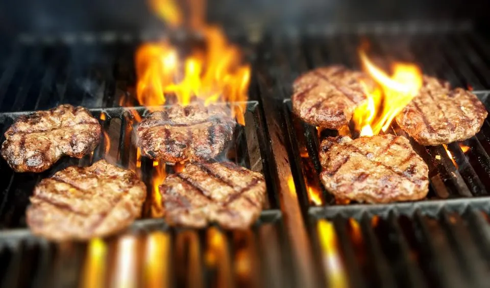 Steaks hachés saisis sur le grill avec des flammes