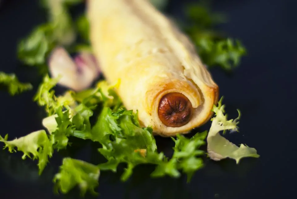 Pain saucisse doré sur un lit de salade