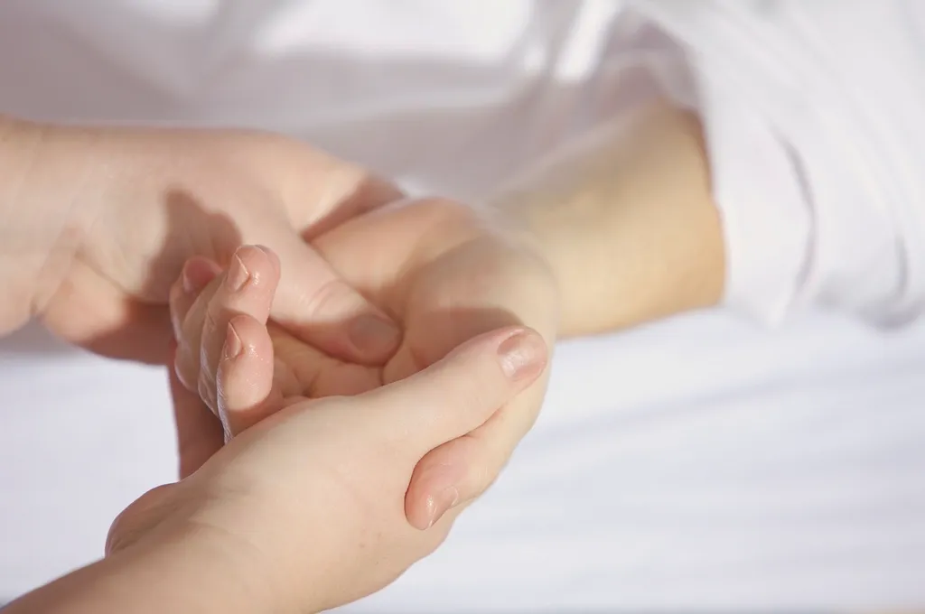 Mobilisation douce du poignet entre les mains d'une kinésithérapeute