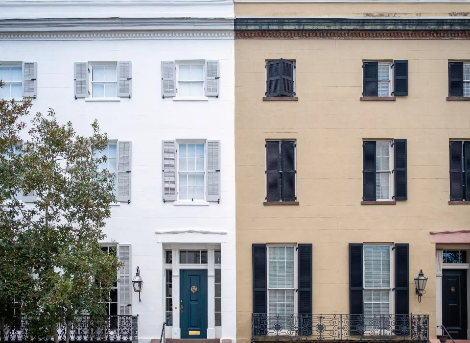 Façades de maisons de ville blanche et beige aux châssis noirs