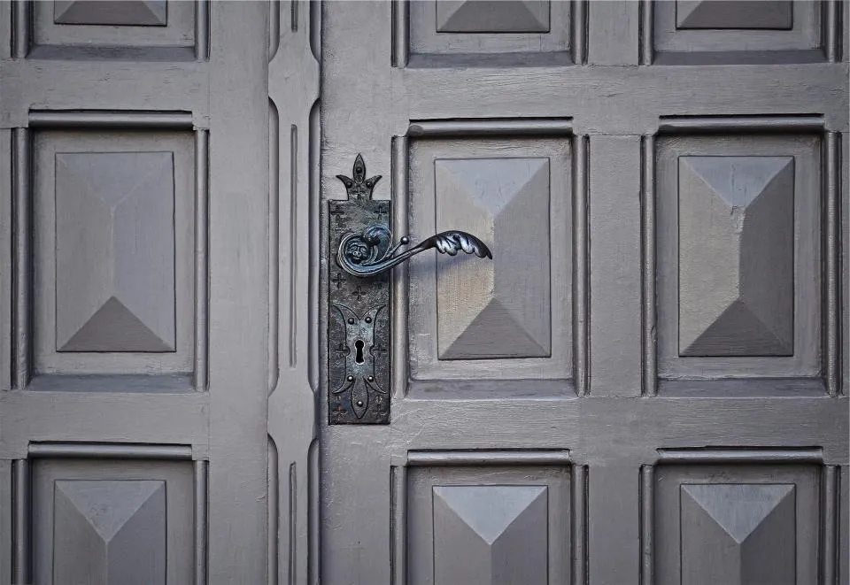 Porte d'entrée moulurée avec poignée en fer forgé