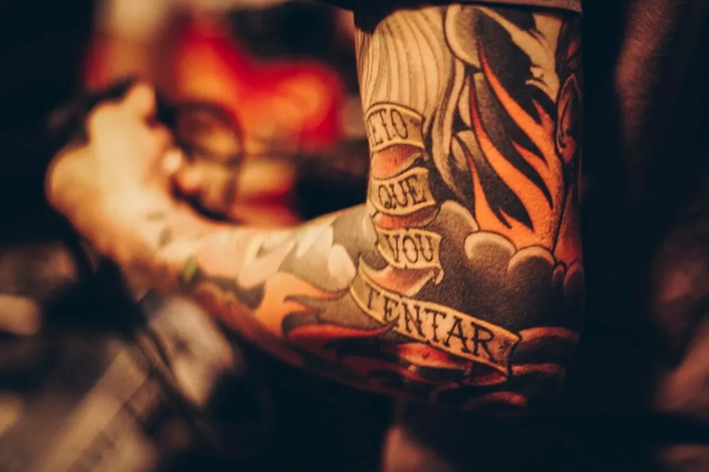 Bras tatoué avec lettrage sous une lumière chaude
