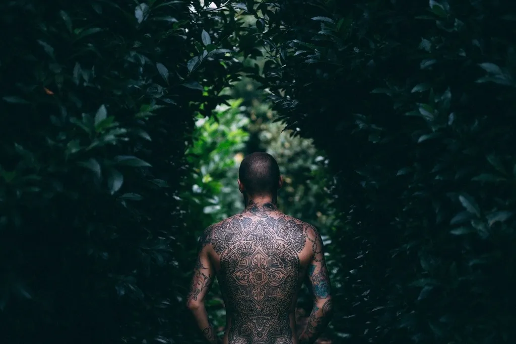 Dos entièrement tatoué dans un sous-bois
