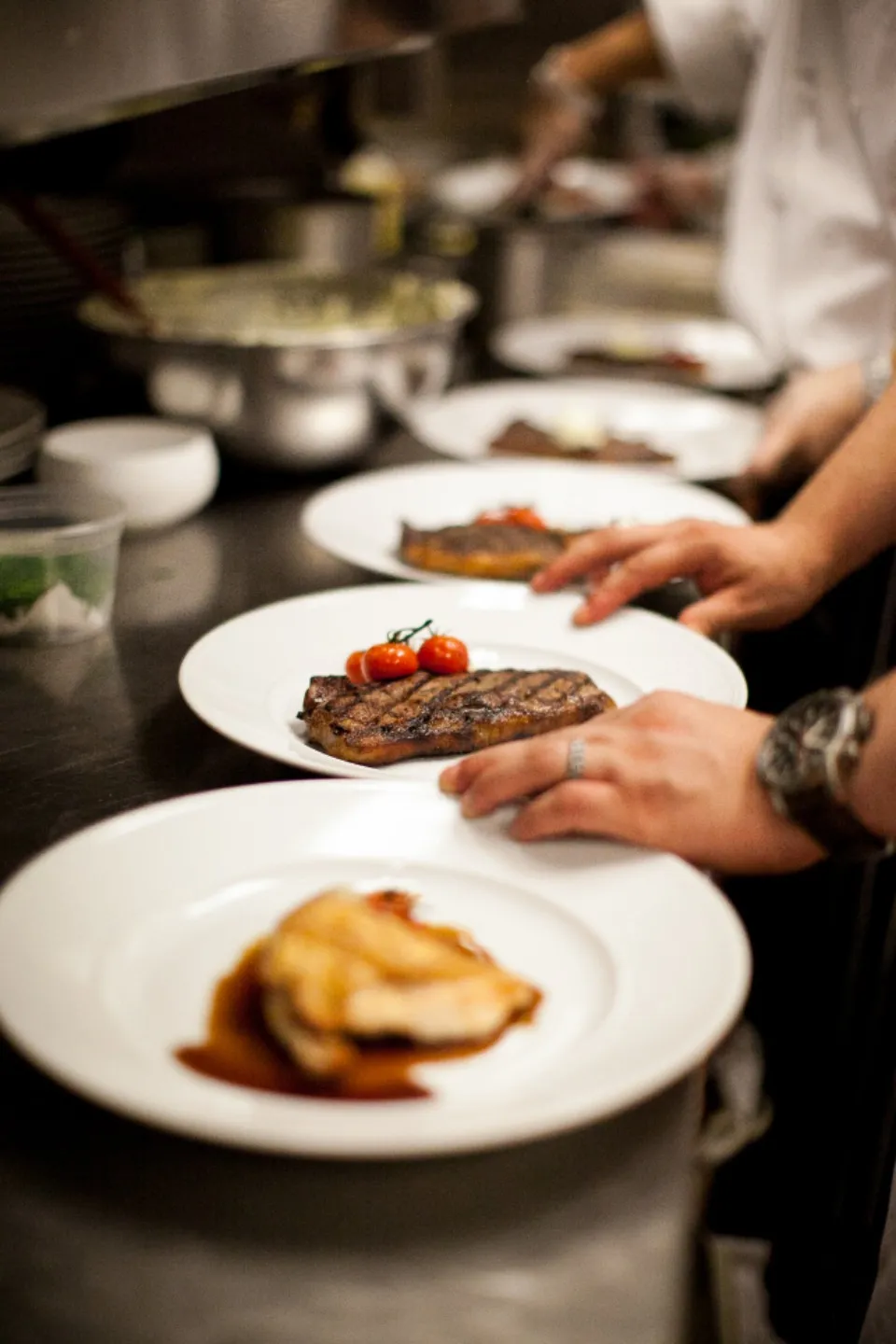 Assiettes de viande grillée en cours de dressage en cuisine